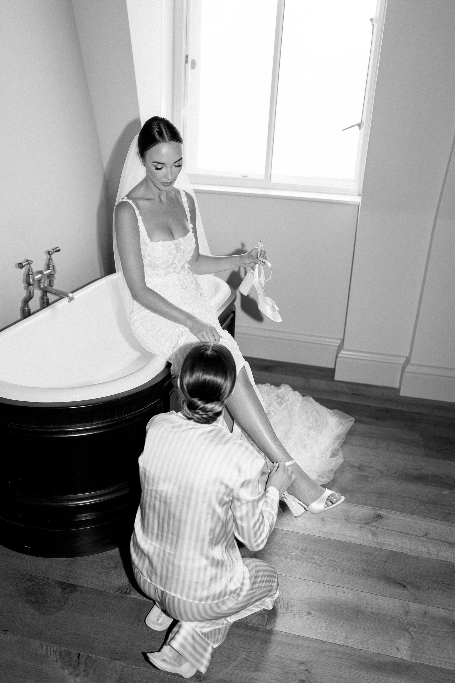 Wedding dress preparation scene with vintage bathtub and wooden floors.