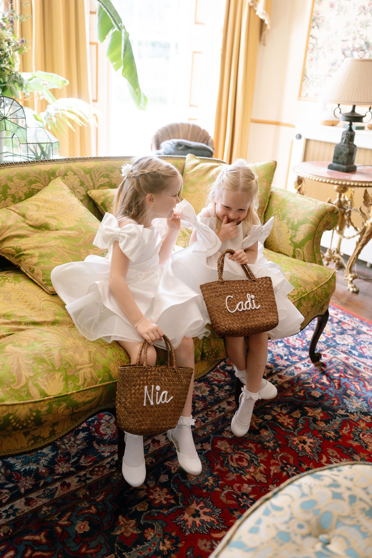Young attendants with personalized baskets play on a patterned rug.