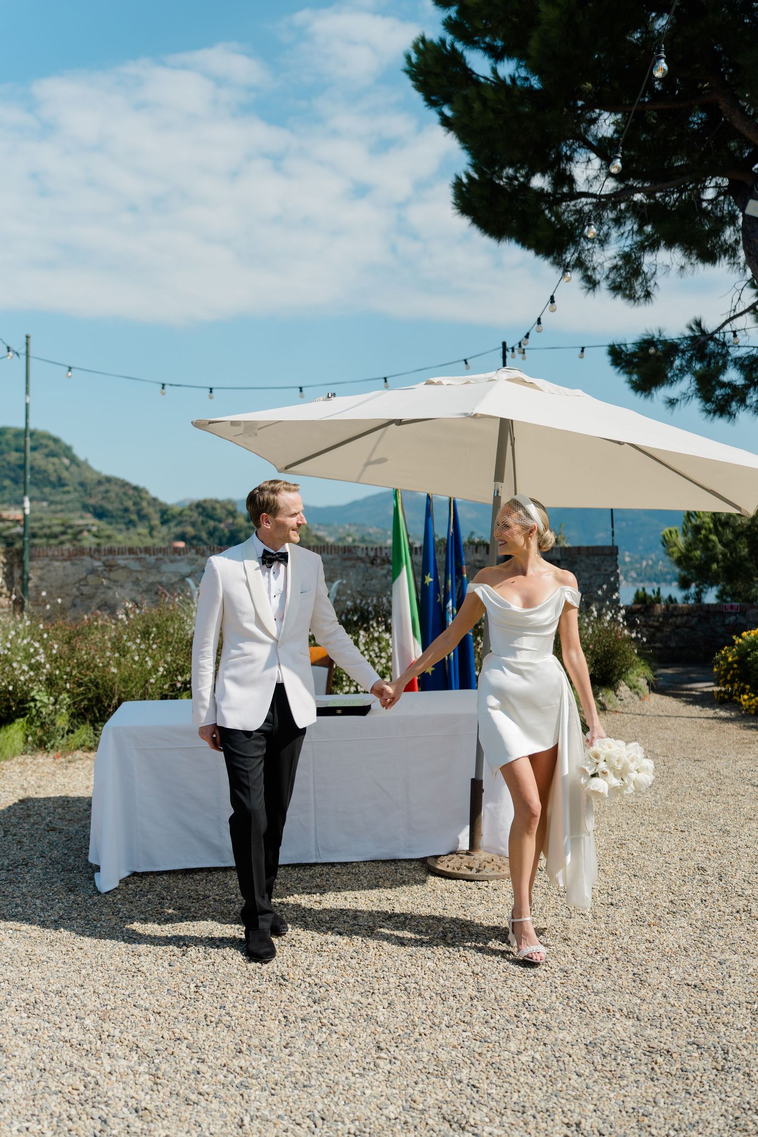 Bride and groom walk hand in hand after ceremony in Portofino, Italy.