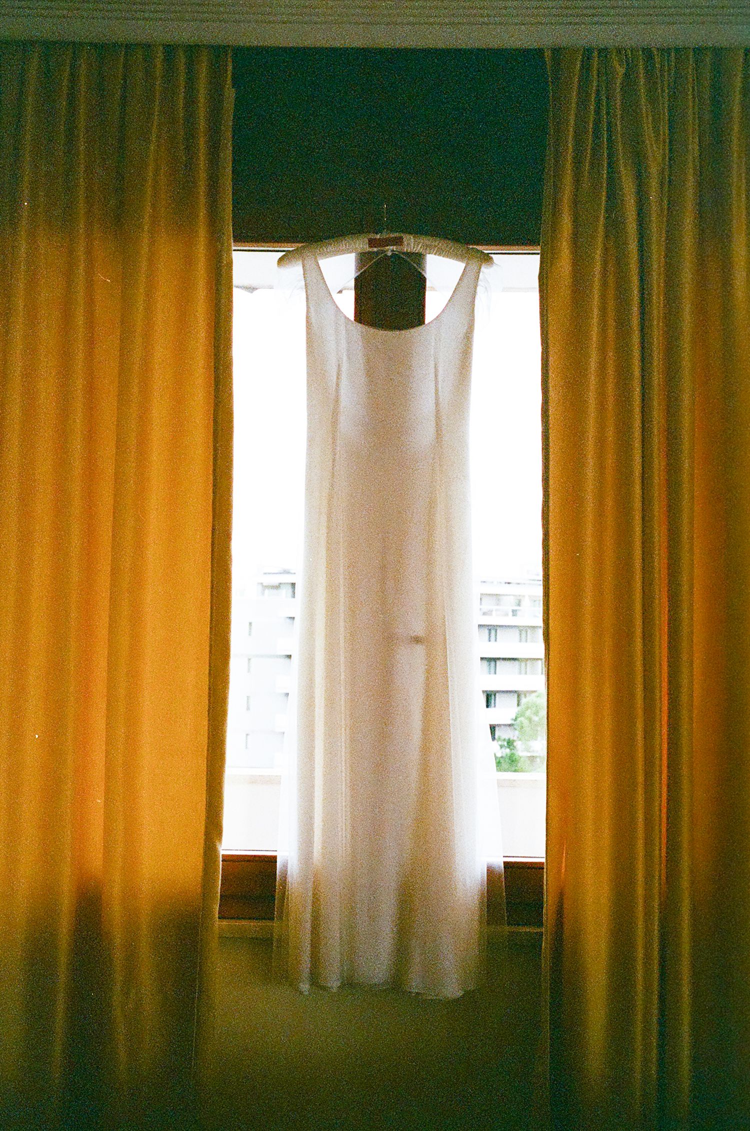 Sunlit room interior with golden curtains and white sheer panels creating a warm atmospheric glow through windows.