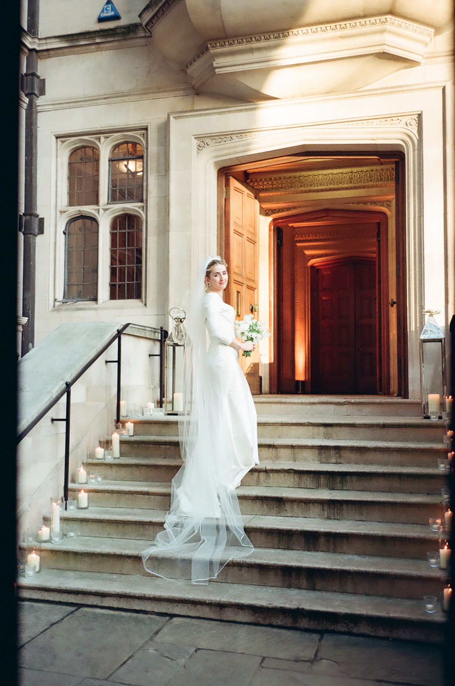Elegant wedding photography at grand stone building entrance with ornate architectural details.