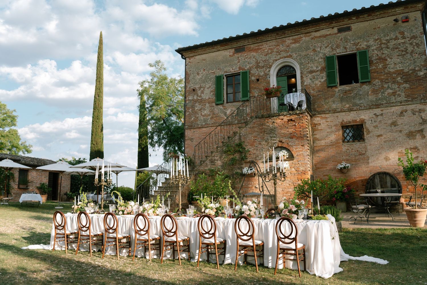 Panoramic view of a rustic Tuscan villa with chairs set up for an outdoor event.