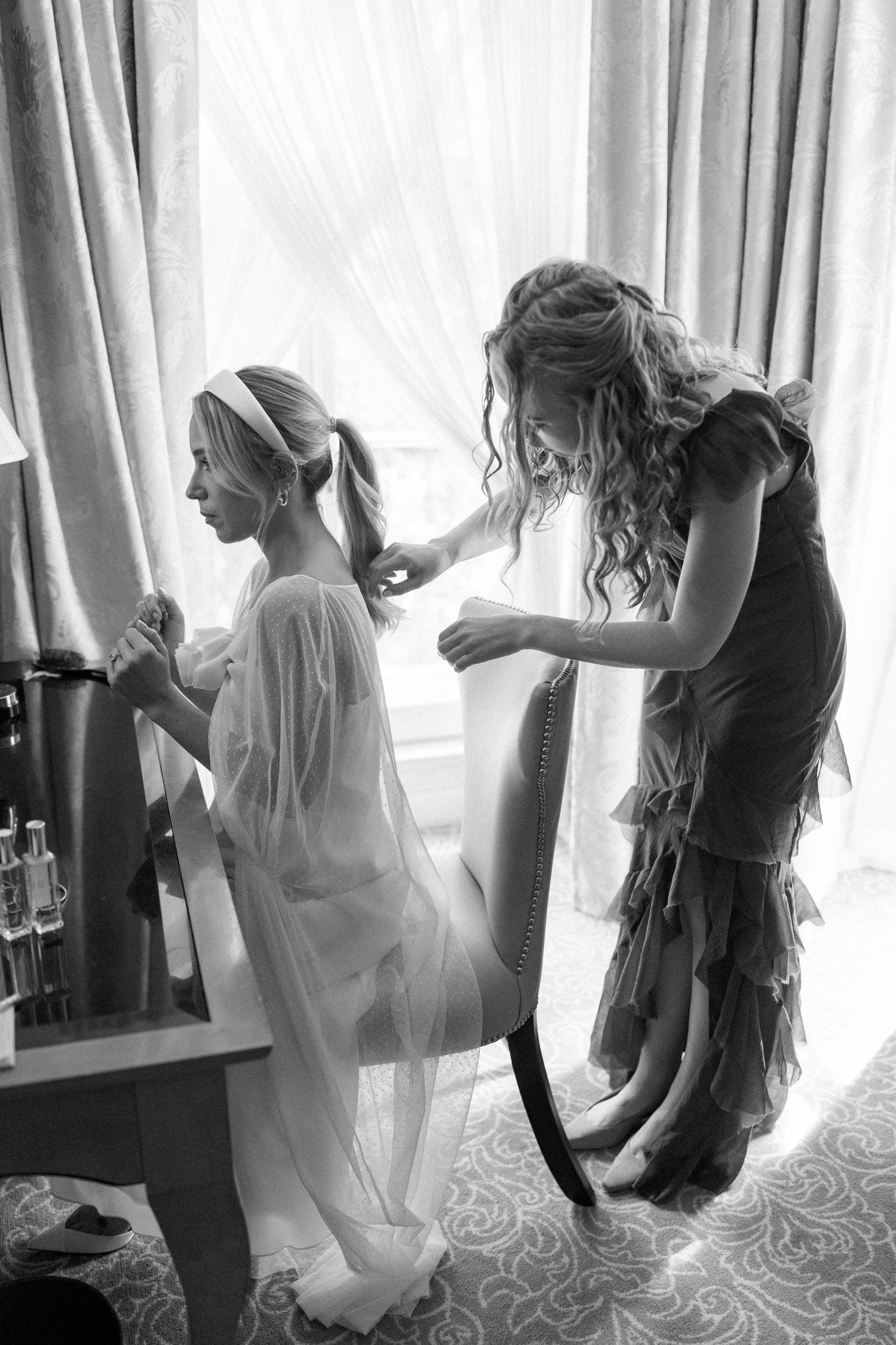 Black and white photo sequence showing a bride getting ready in front of window with flowing curtains.