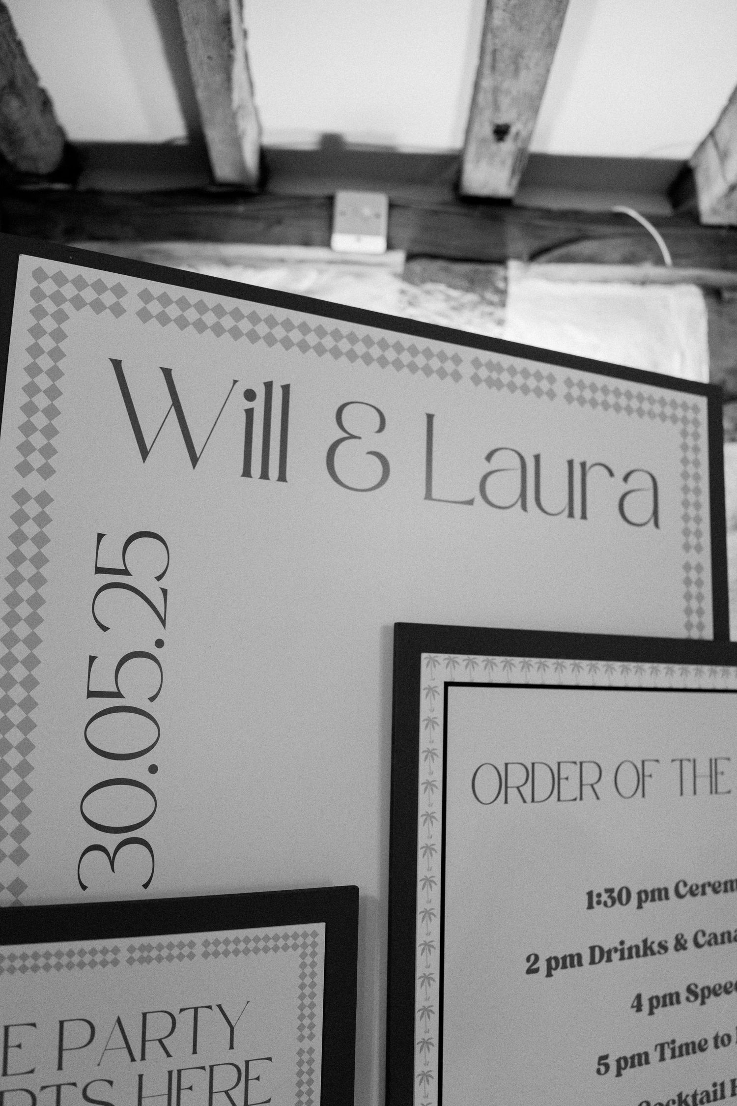 Black and white wedding timeline signs displayed in a row showing event schedule details.