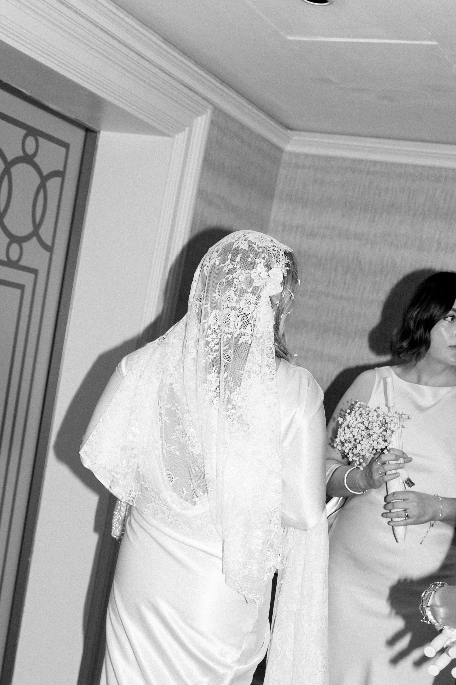 Sequence of a person in white moving through a hallway with patterned carpet.