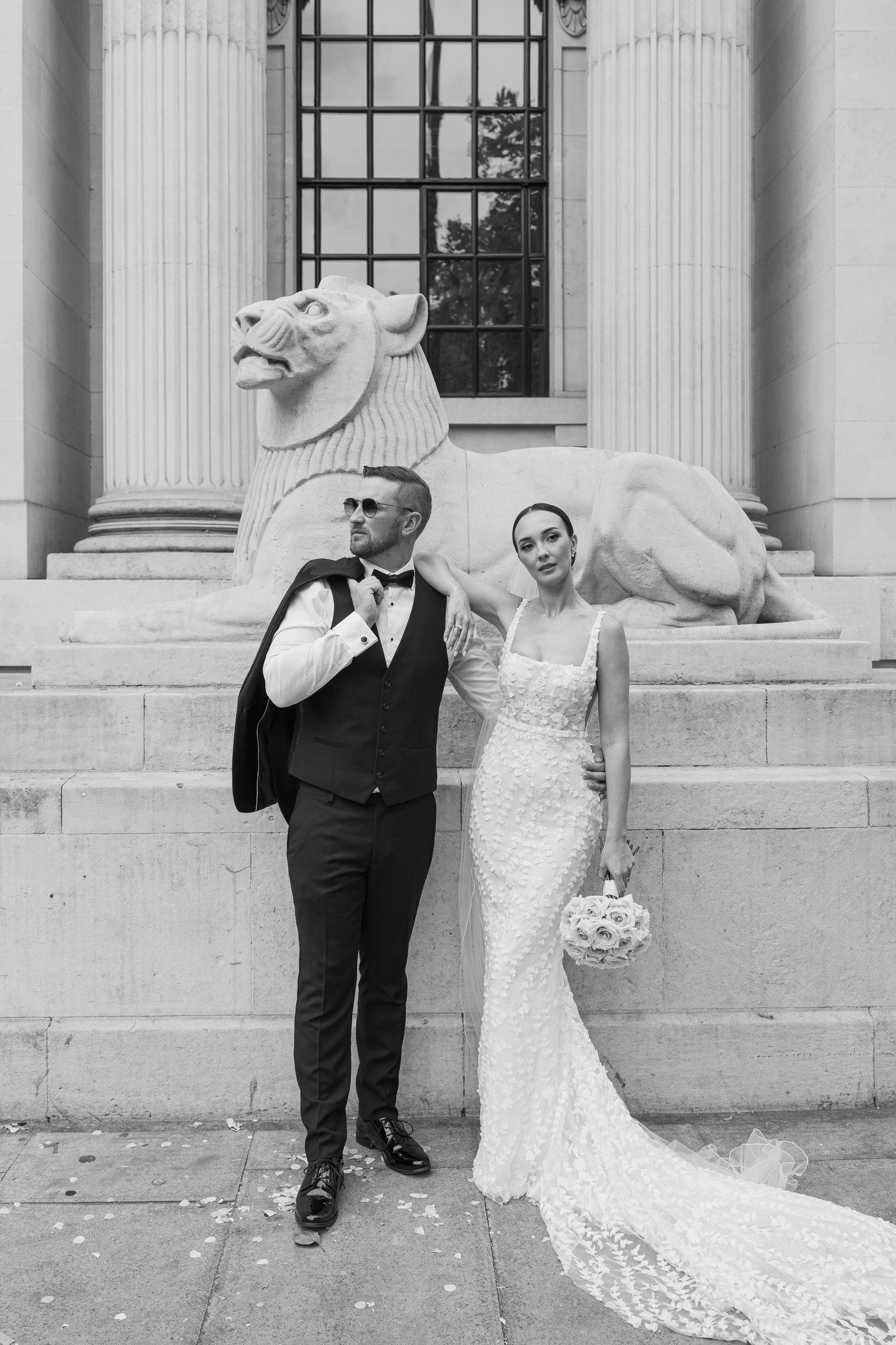 Artistic wedding photos captured against classical architecture with stone lions.