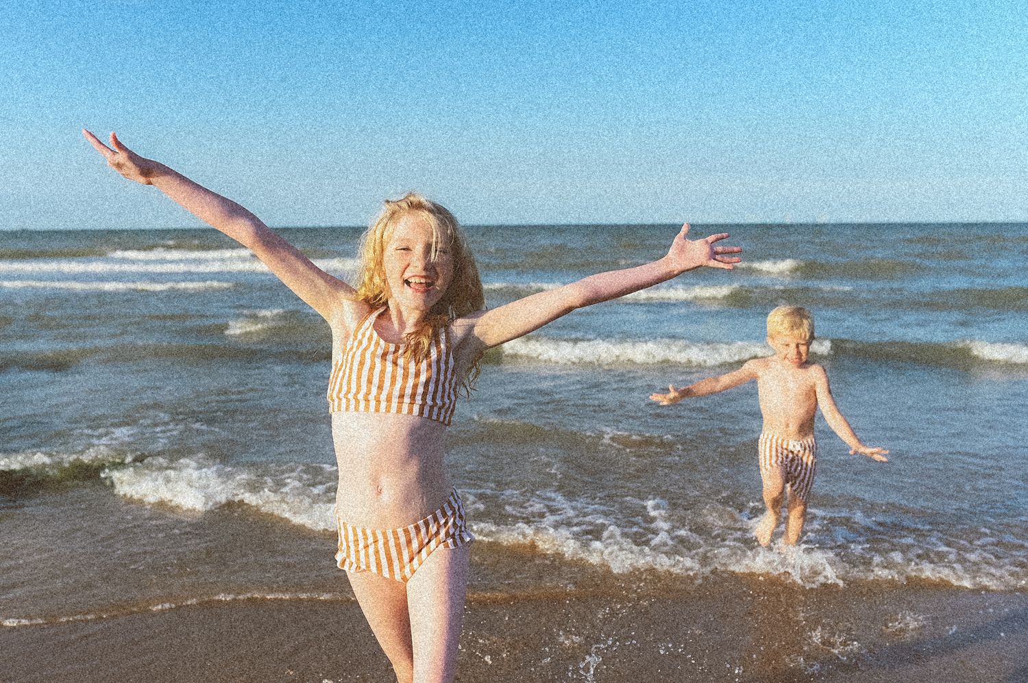Joyful beach moments captured with people jumping in ocean waves.