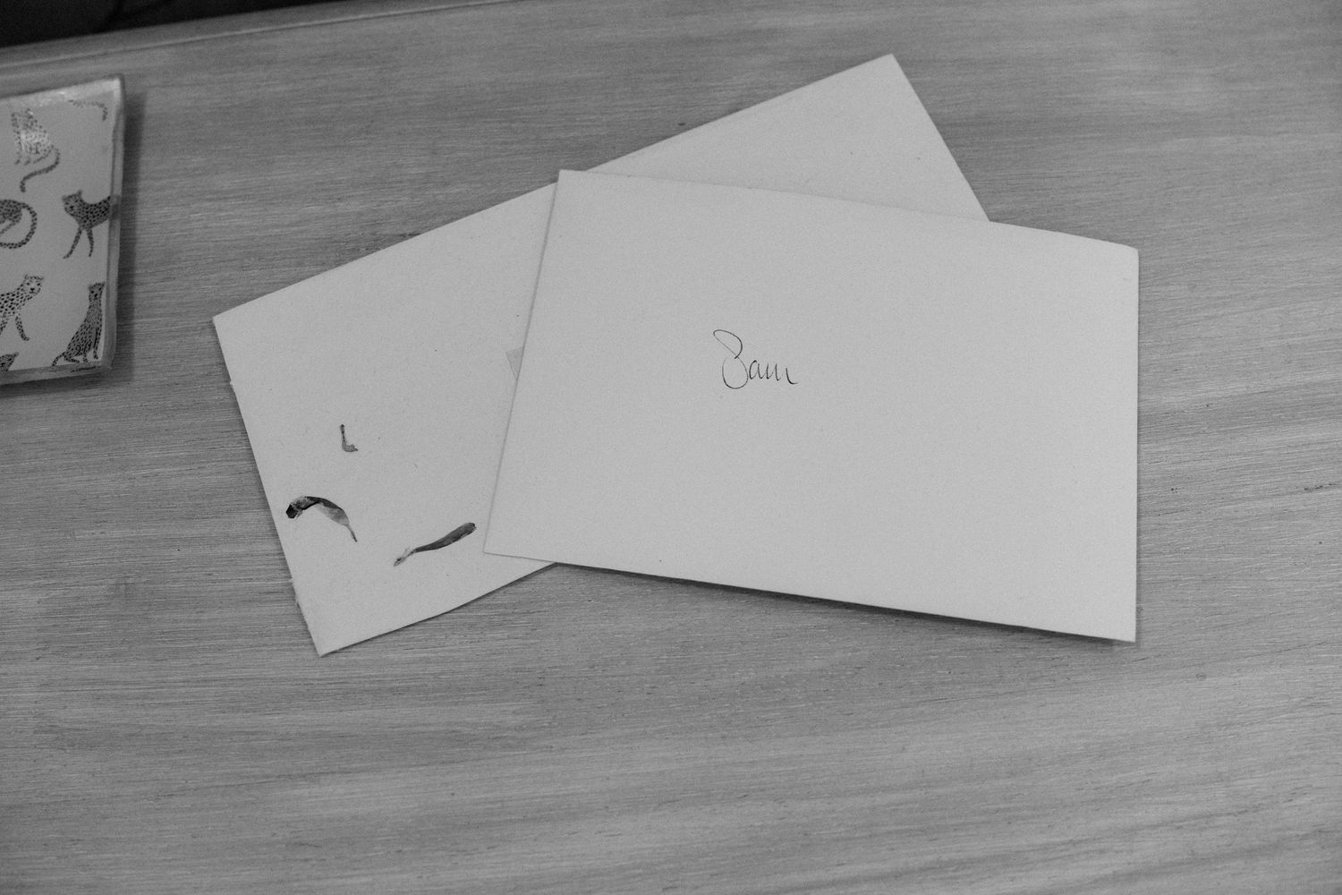 Black and white image of blank paper cards arranged on a wooden surface.