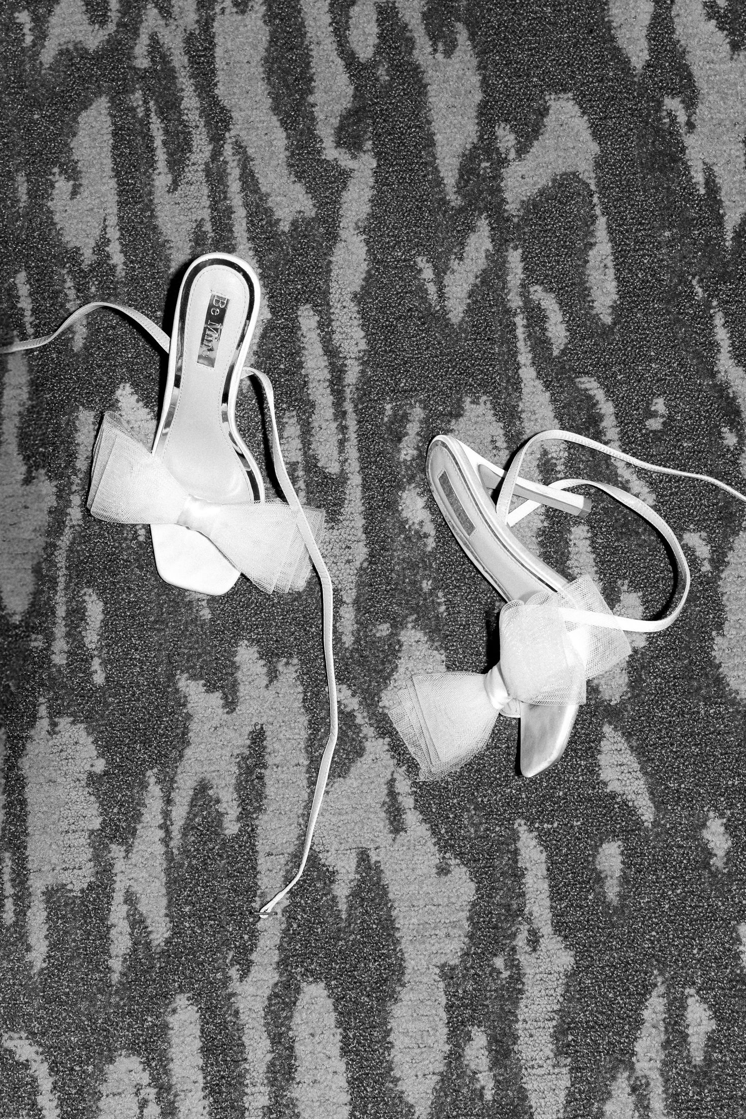 White earbuds arranged on dark patterned carpet.