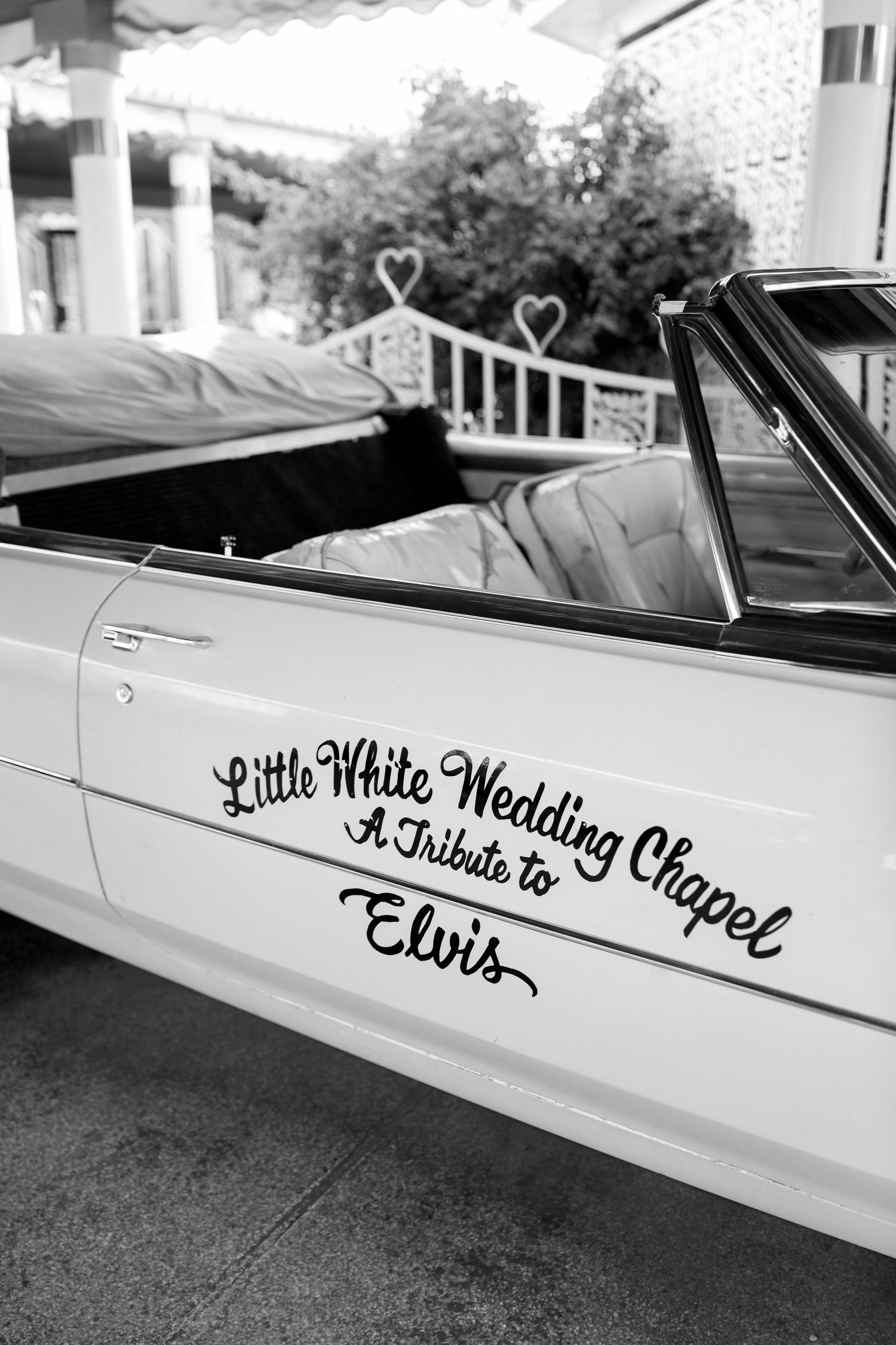 Classic white car with 'Little White Wedding Chapel' text on side.