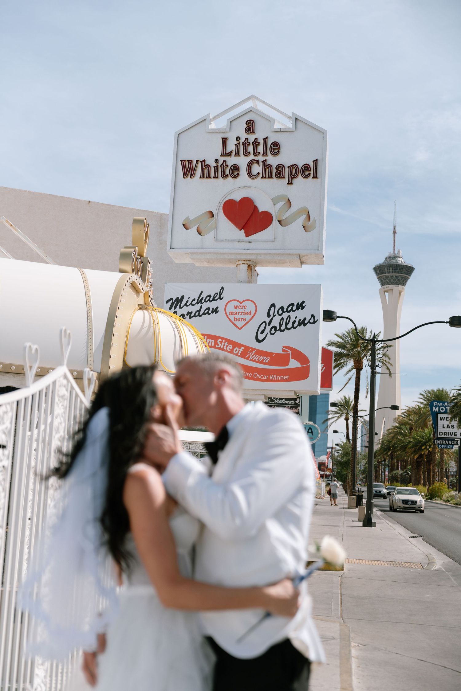 A couple in wedding attire embraces outside the Little White Wedding Chapel in Las Vegas.