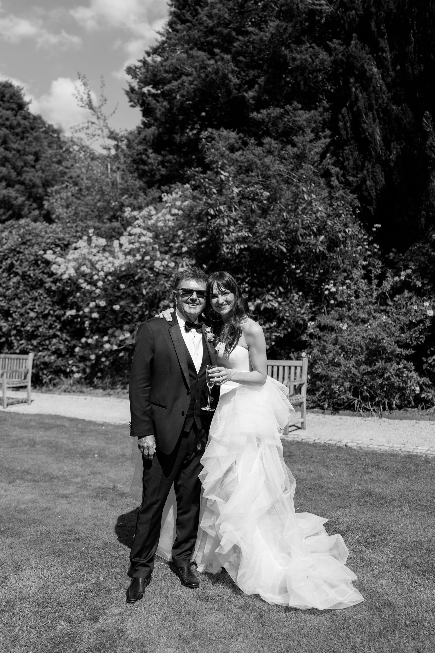 A couple walks together on grass during their wedding day celebrations.