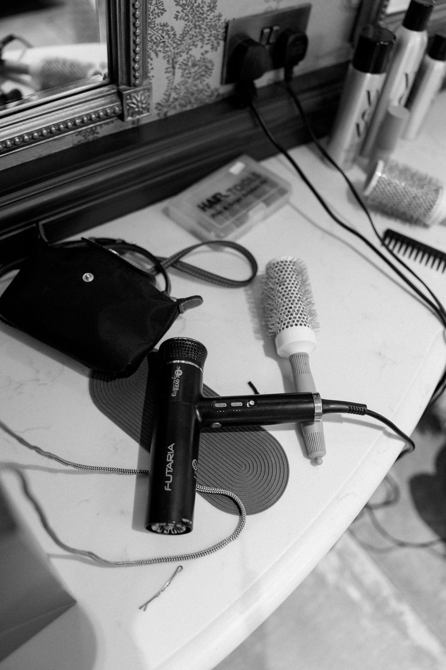Professional microphones and styling tools on vanity table during wedding preparation.