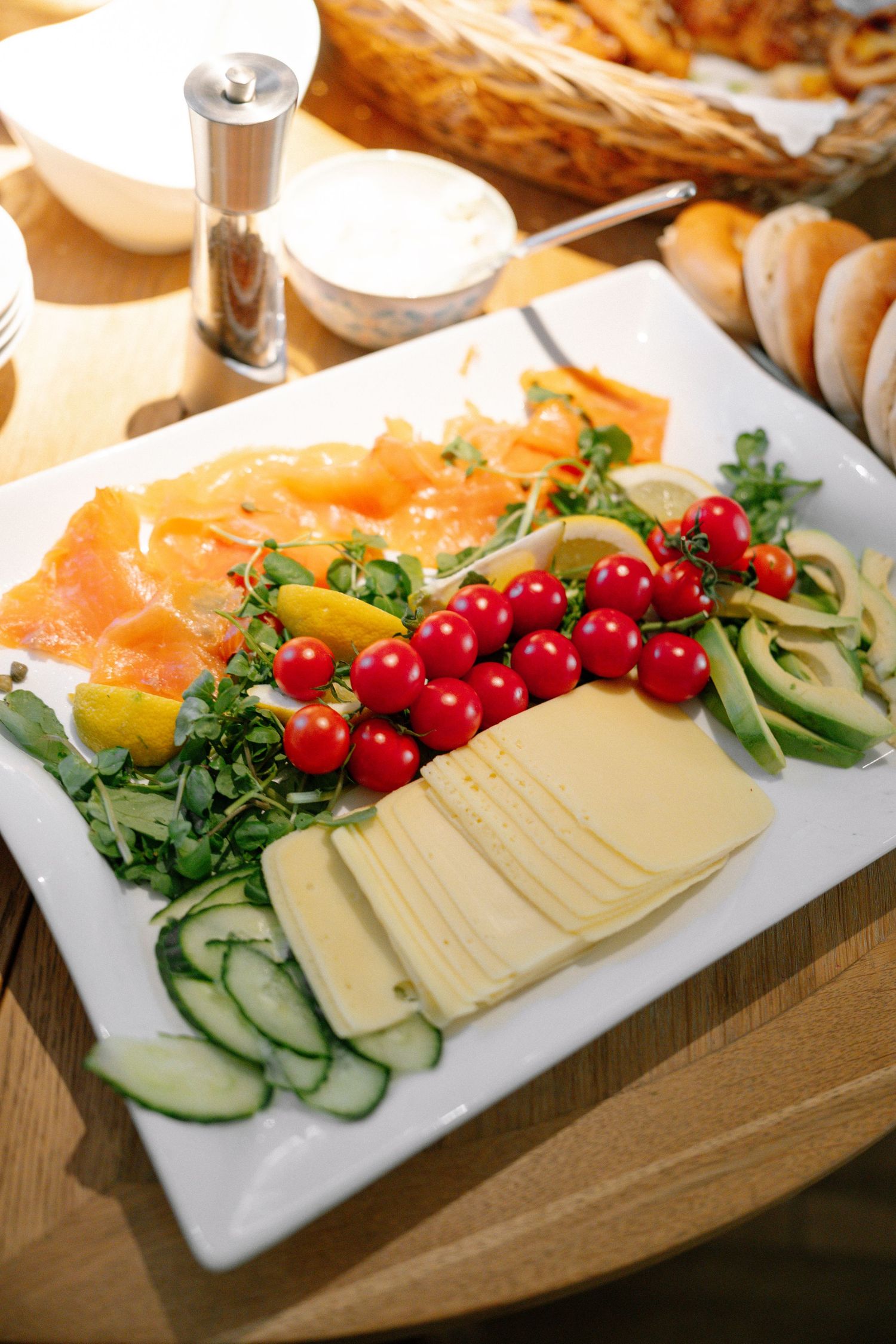 Elegant charcuterie plate with smoked salmon, cheese, cucumbers and cherry tomatoes.