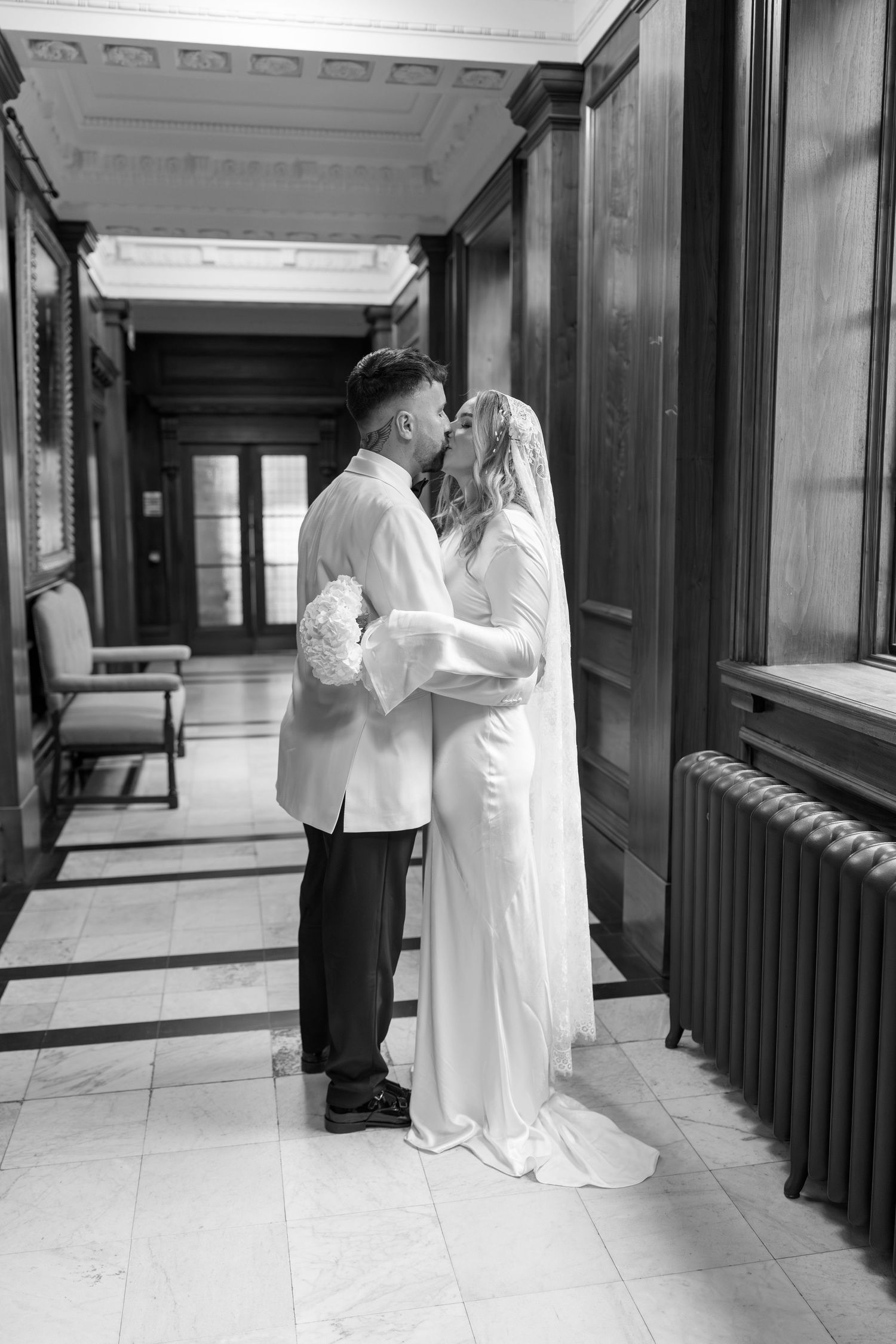 Black and white photos of a couple sharing intimate moments in an elegant hallway.