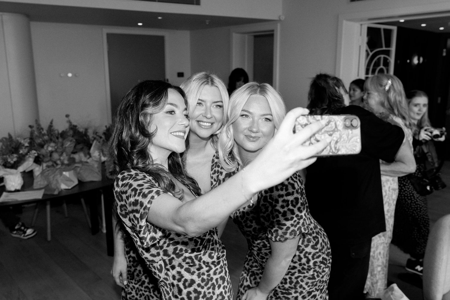 Wedding guests dancing and celebrating at a reception in black and white photography.