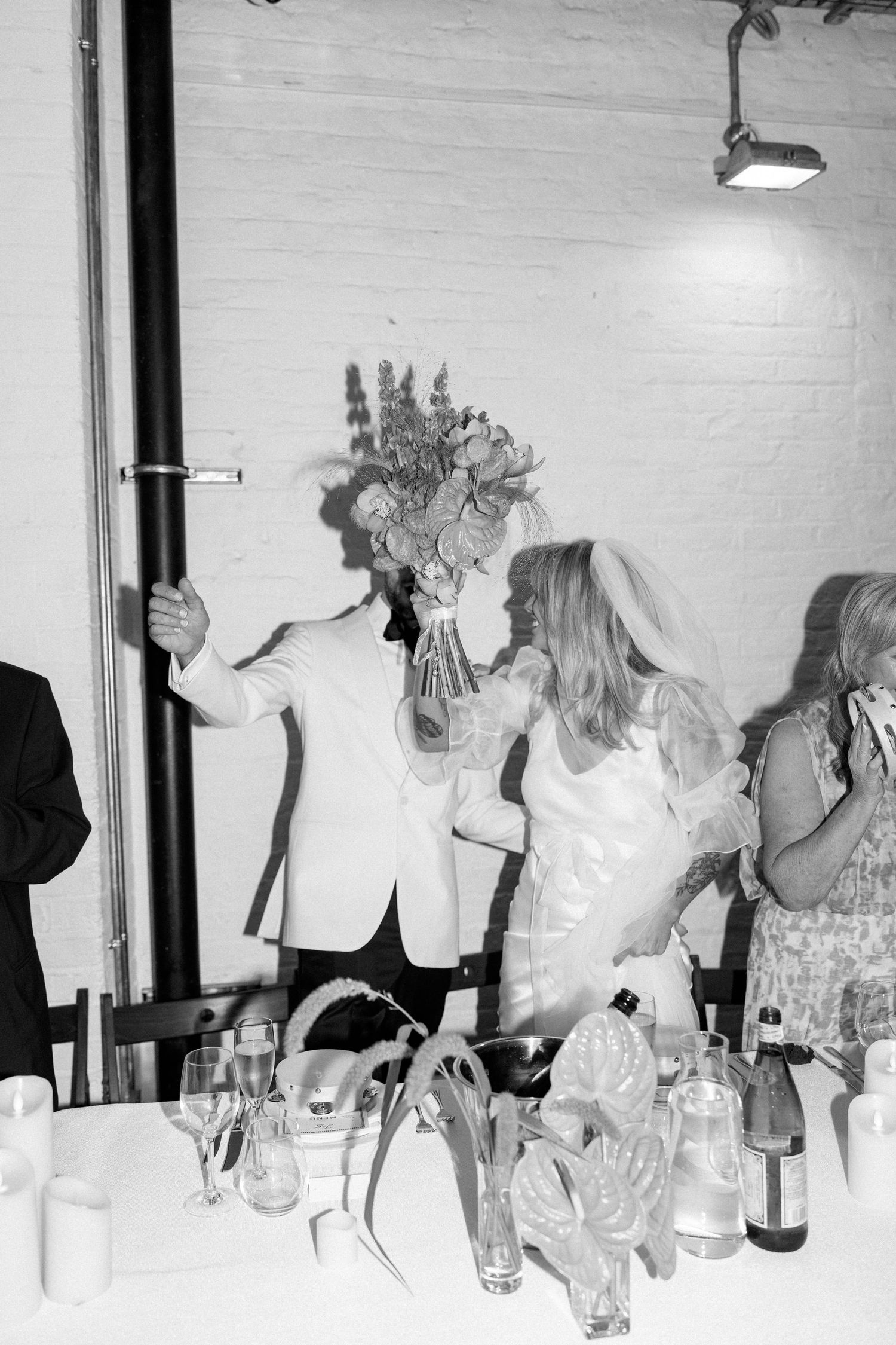Black and white photo of wedding reception celebration with guests.