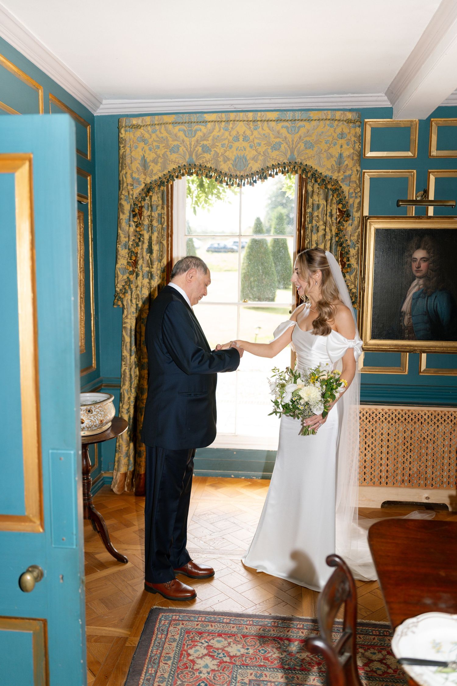 Wedding preparations in a bright blue and gold decorated room with vintage decor.