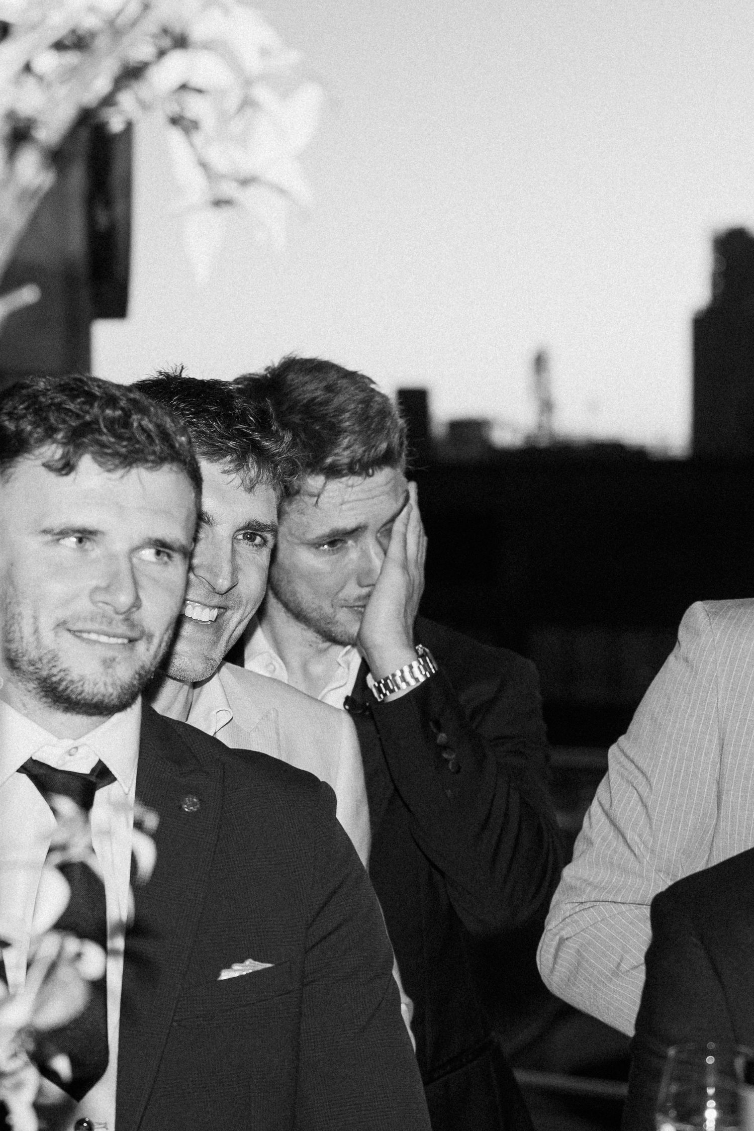 Black and white candid shot of guests enjoying themselves at an evening wedding reception.