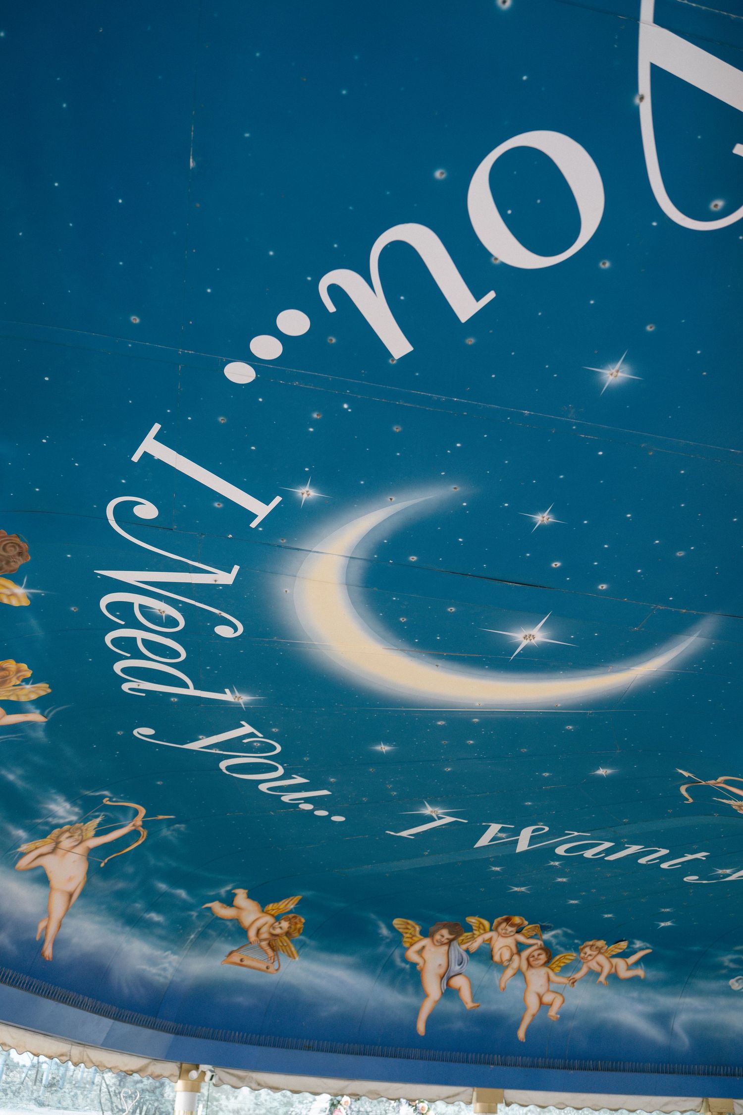 Blue ceiling with painted crescent moon and stars in dreamy wedding venue.