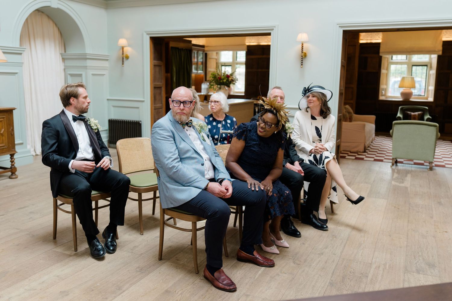 Wedding guests seated during intimate indoor civil ceremony in elegant venue.
