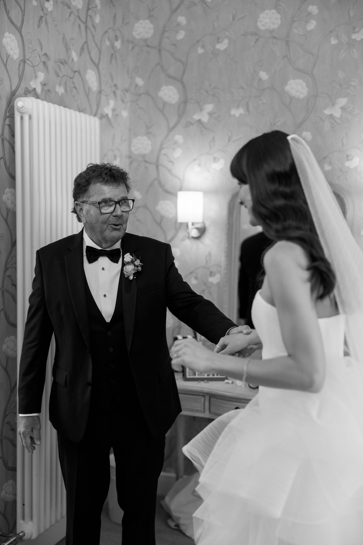 A touching first look moment between two people in formal wedding attire.