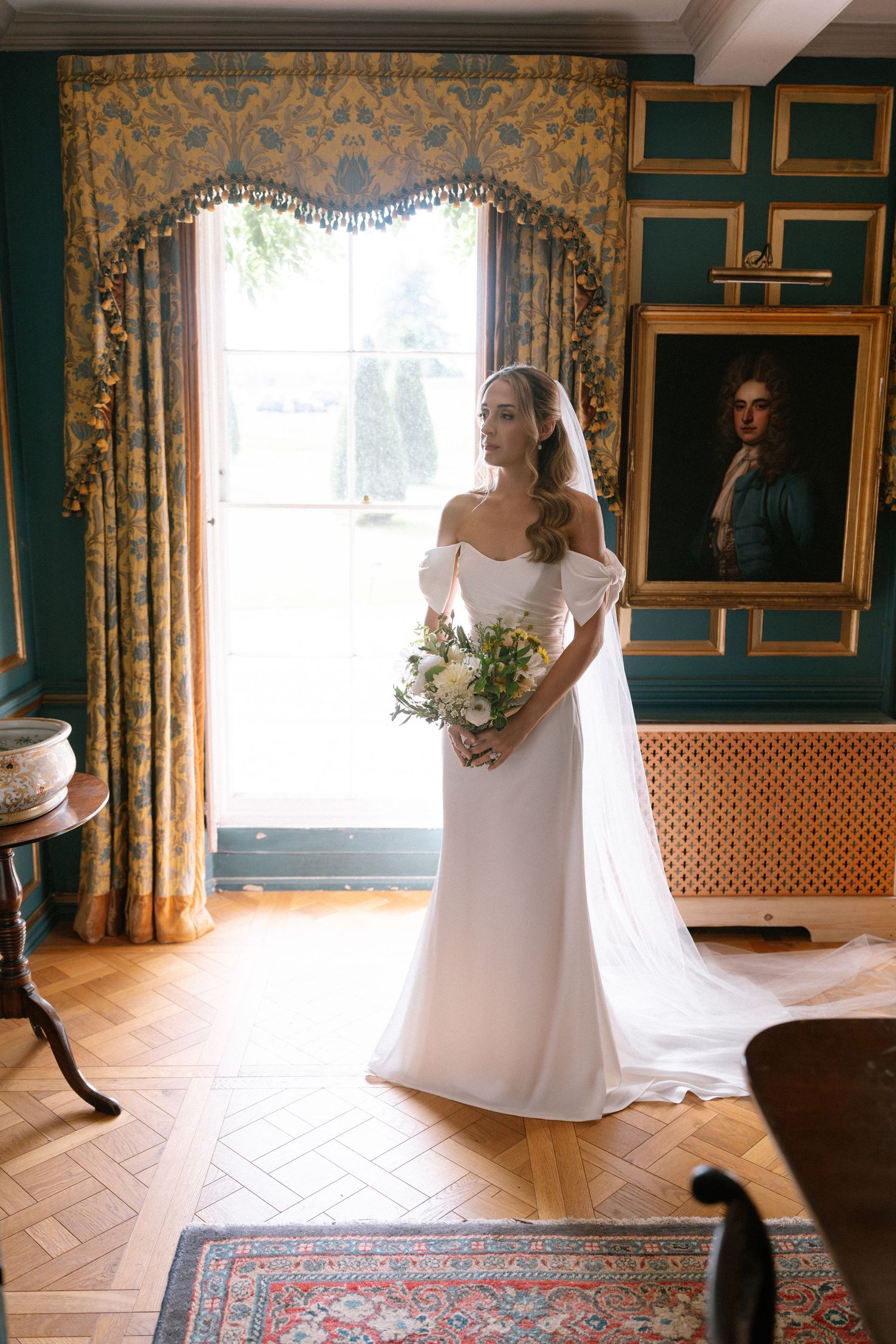 Elegant bridal portrait in a room with green walls and ornate gold curtains.