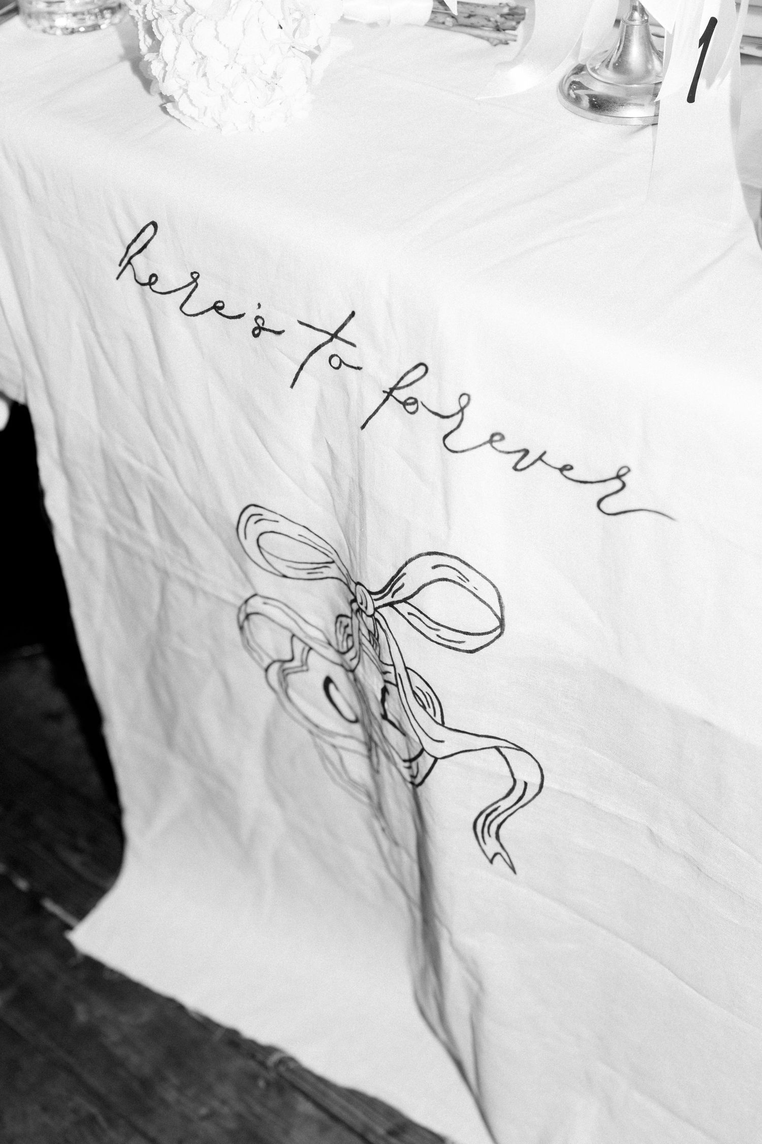 Black and white detail shots of handwritten text and sketches on white fabric.