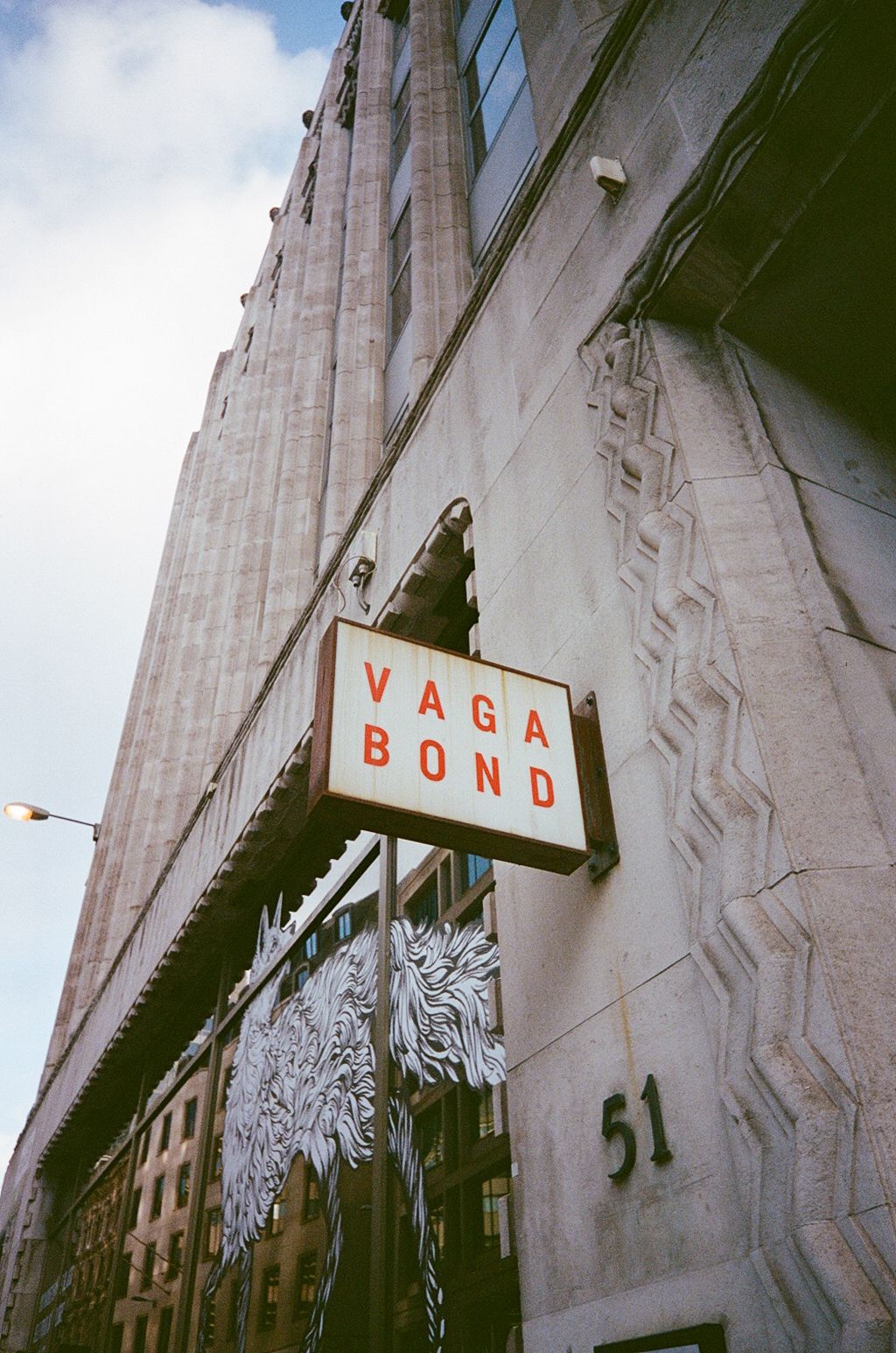 Low angle view of Vagabond sign on Art Deco building facade in city.