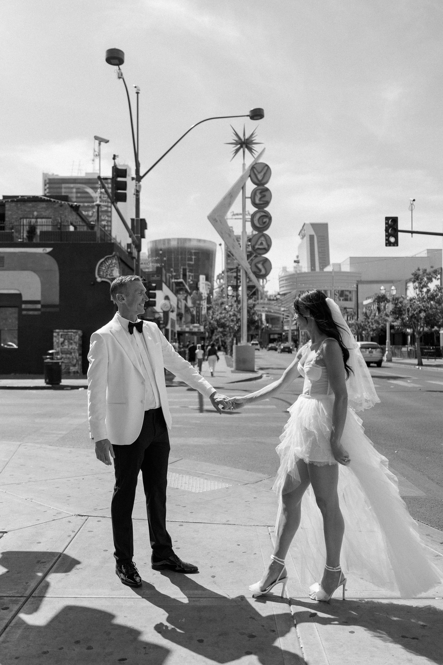 Black and white sequence of dance poses on a downtown street with vintage signage.