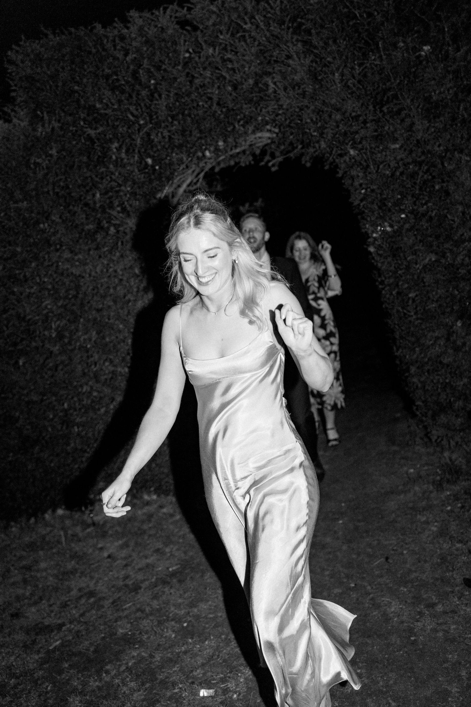 Person in white dress dancing in dark setting with dynamic movement.