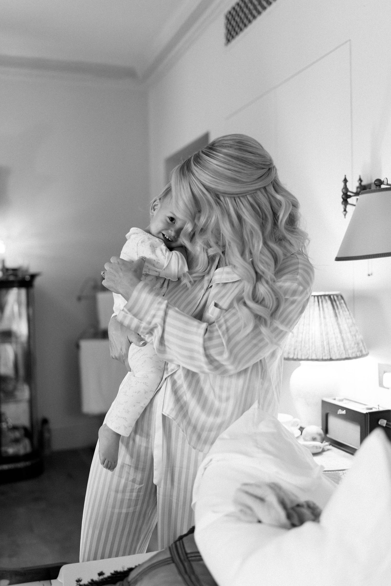 Person in striped sleepwear lying on white bedding.