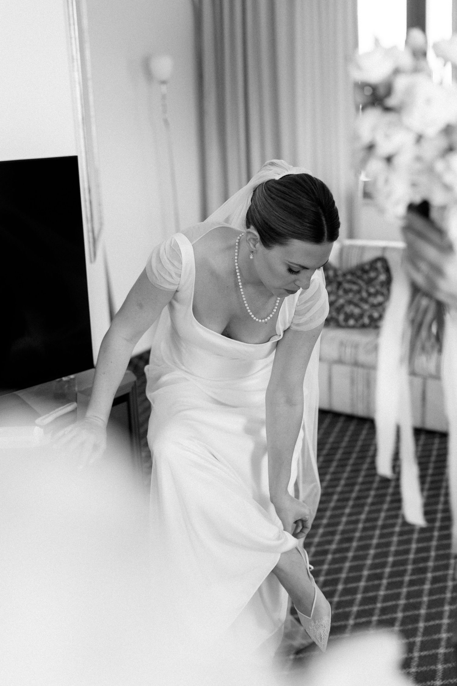 Black and white sequence showing someone adjusting a white dress.