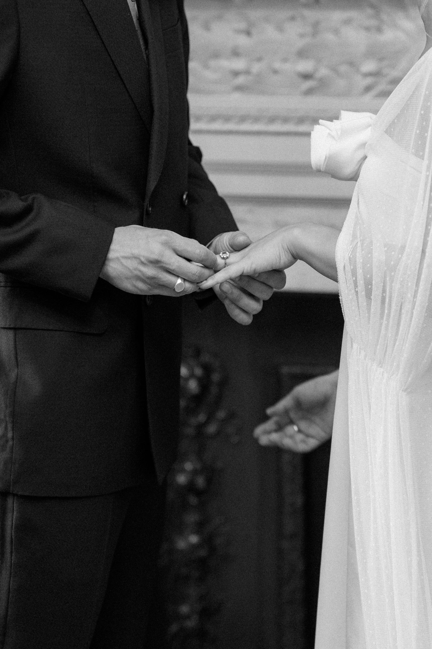Close-up of wedding ring exchange during intimate ceremony.
