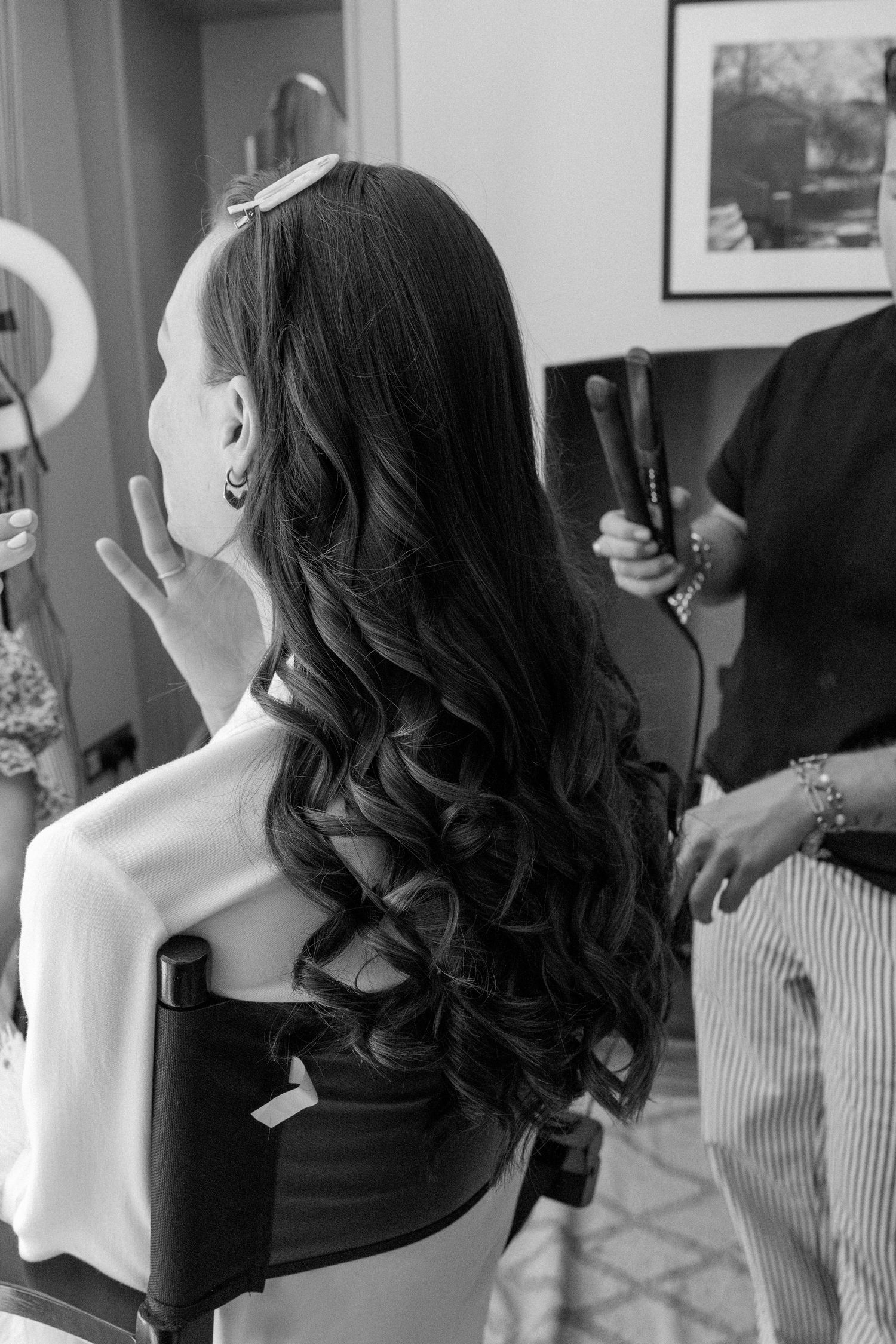 Bridesmaids with dark curled hair getting ready for a wedding celebration.
