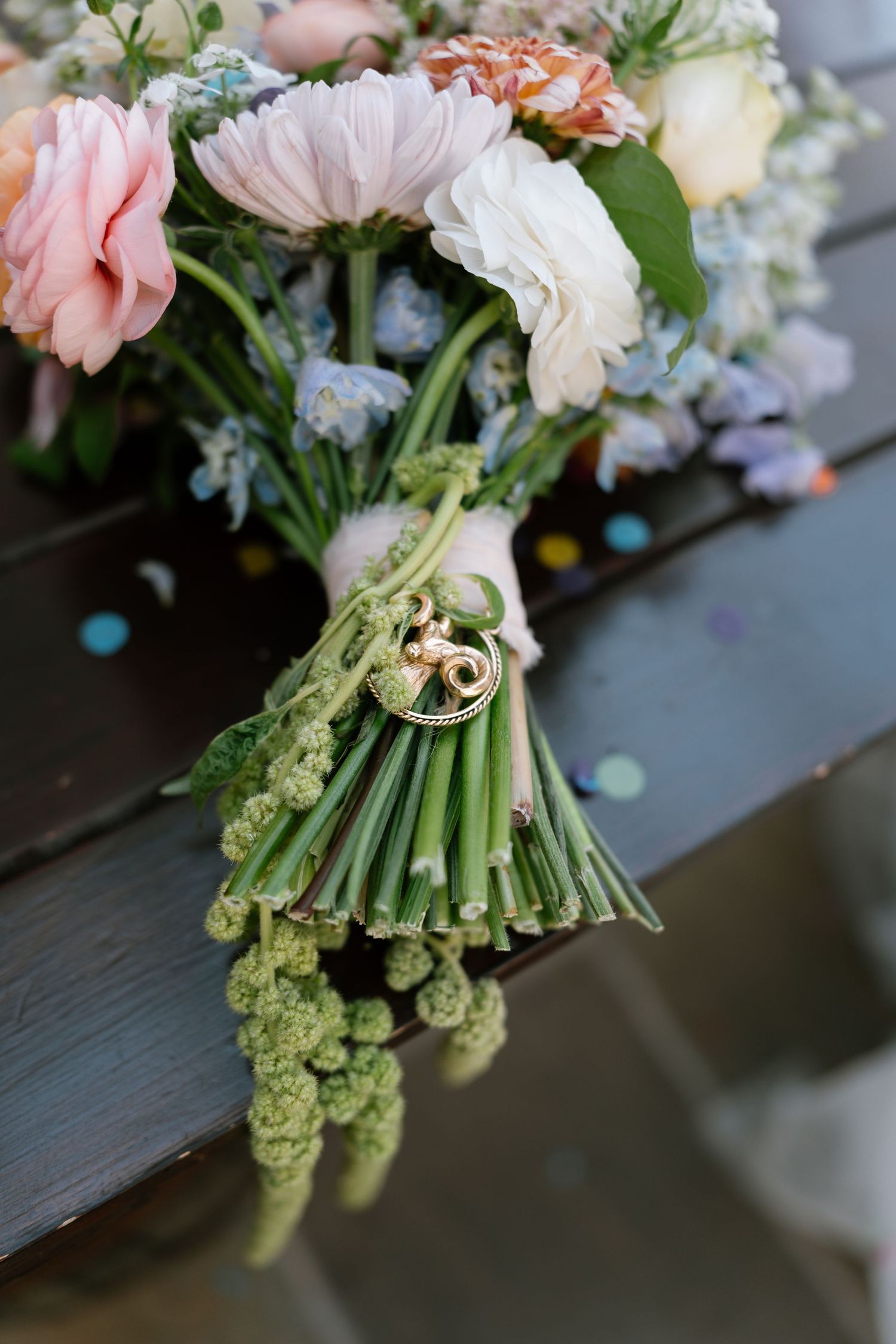 Close-up of a delicate bridal bouquet with pink and white flowers tied with ribbon.