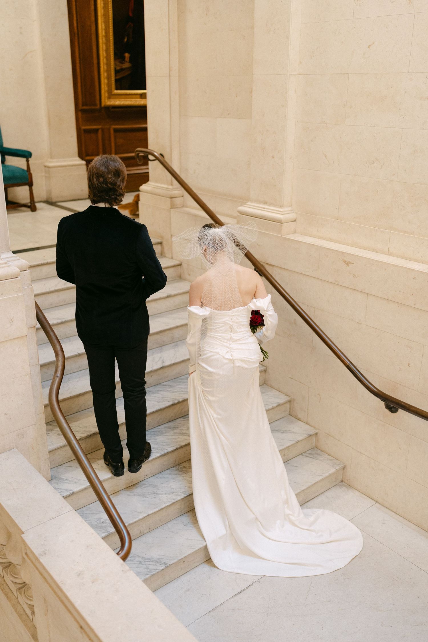 A sequence showing movement up marble stairs with handrails in an elegant building interior.