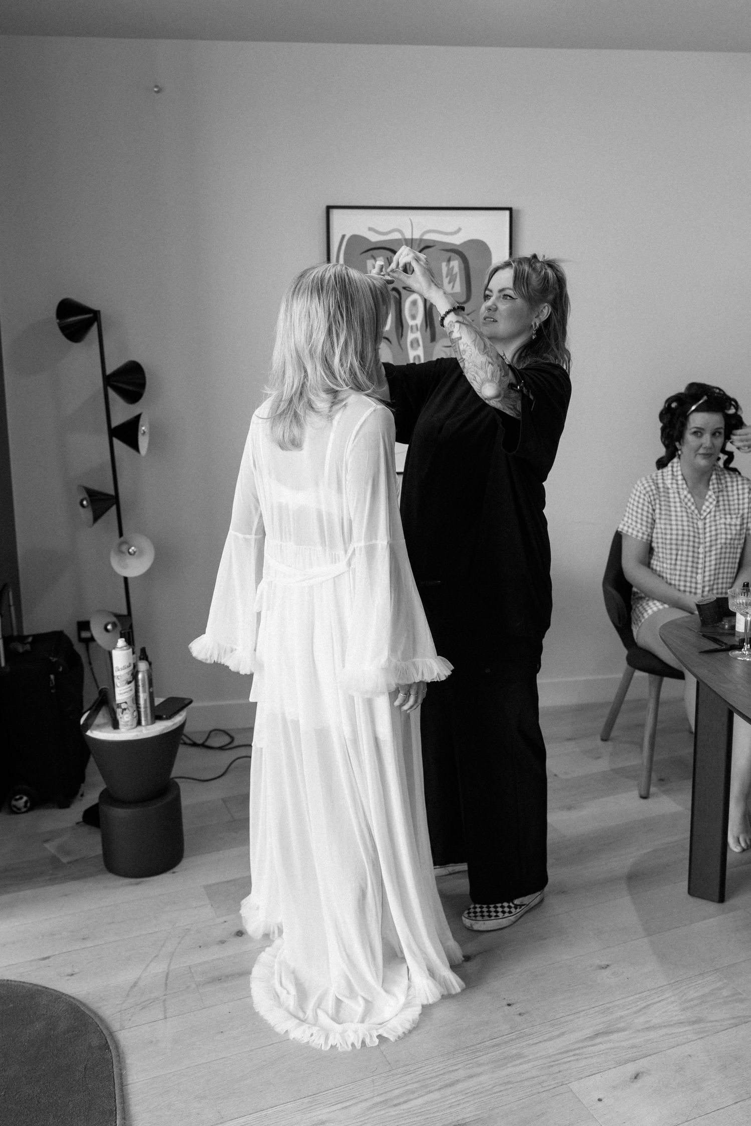 Behind the scenes black and white photos of clothing preparation in a bright room with wooden floors.