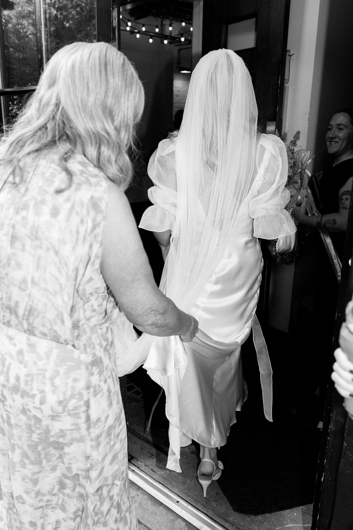 A group in white attire walking through a venue during a wedding celebration.
