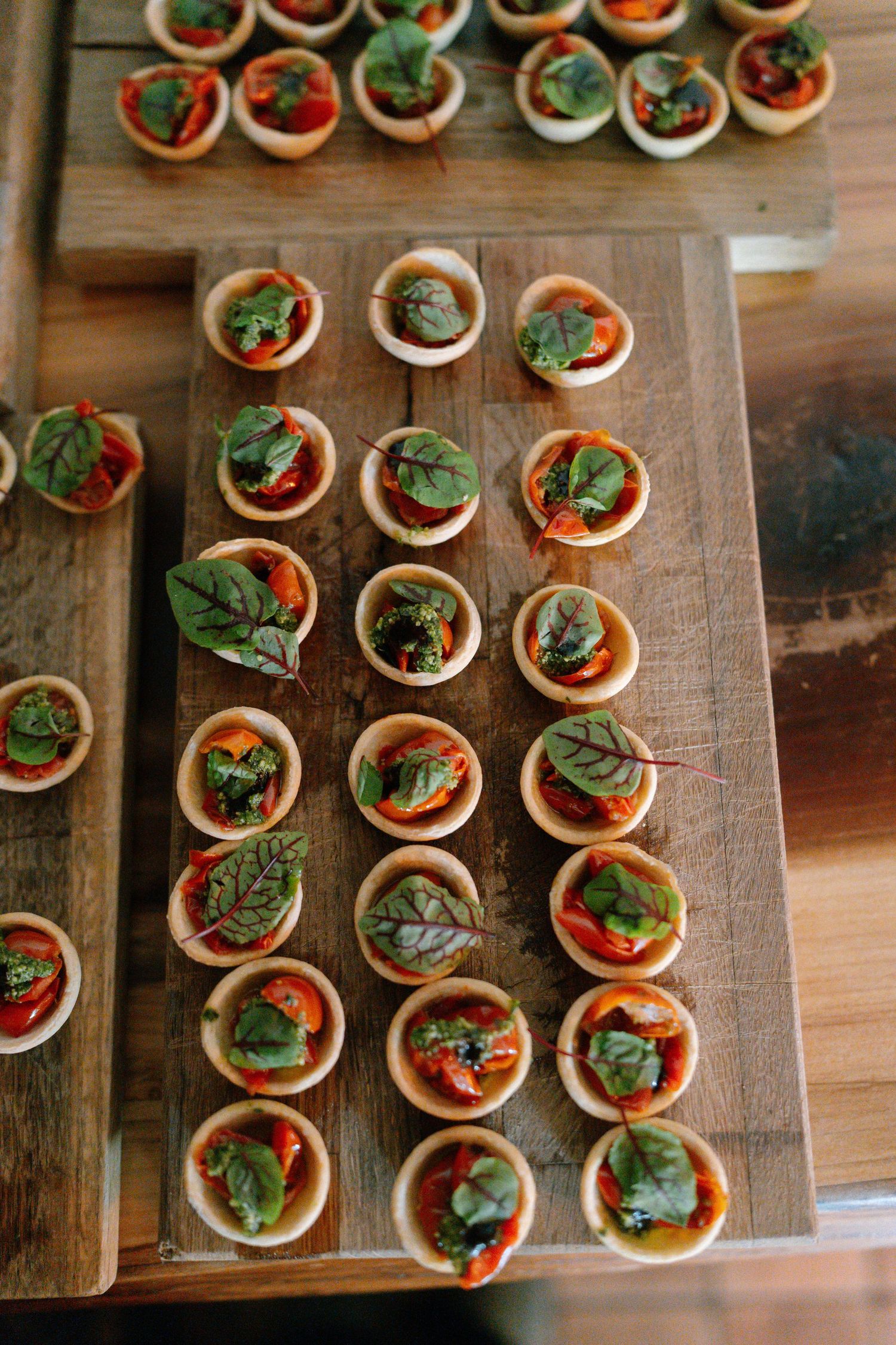 Overhead view of appetizer canapes arranged on wooden serving boards.