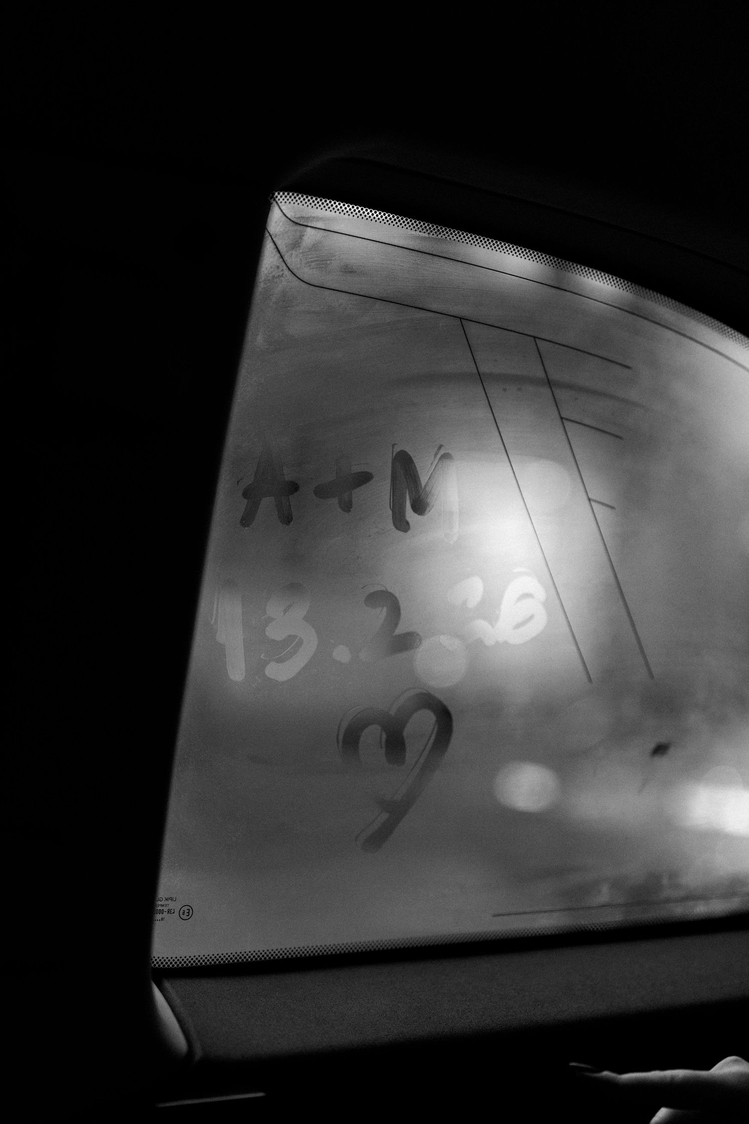 Black and white photo of foggy car window with A+N, date 13.2.26, and a heart drawn in condensation.