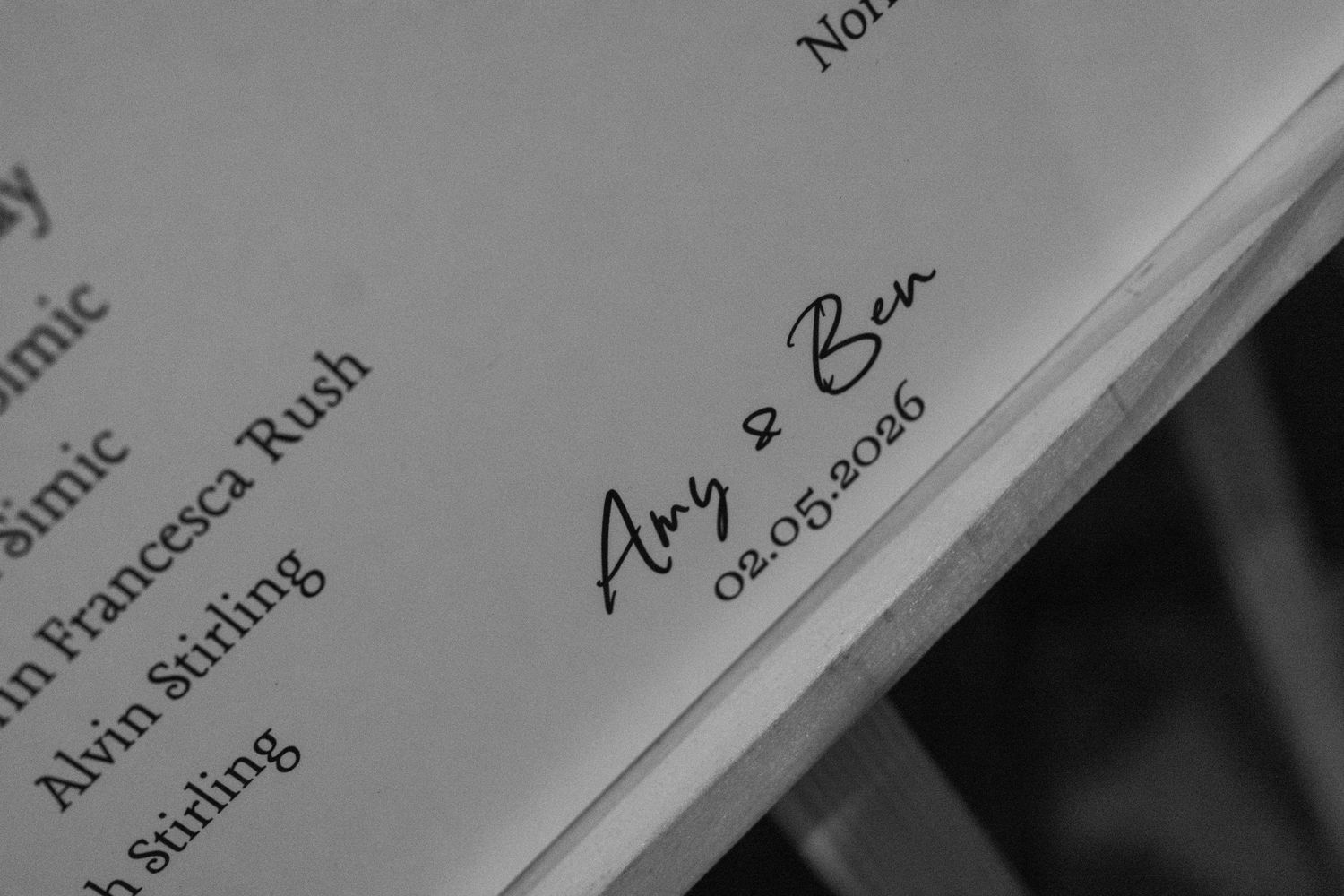 Black and white photo of a wedding program signed by Amy and Ben dated 02.05.2016.