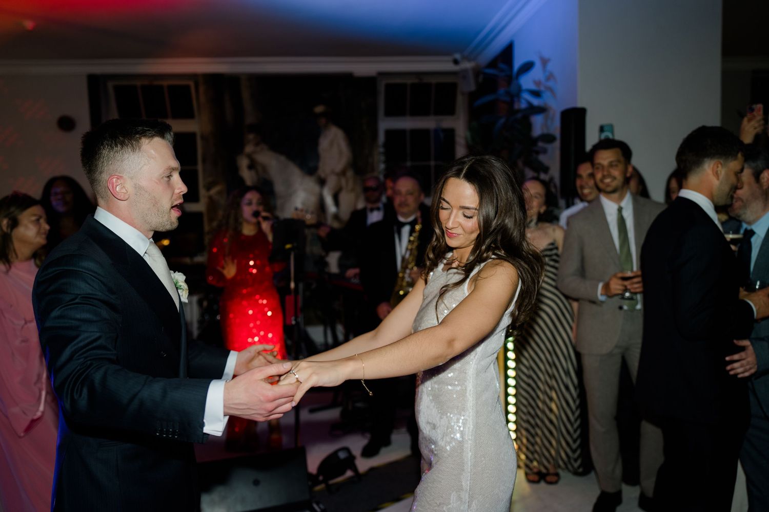 Bride and groom share a dance together at their colorfully lit wedding reception.