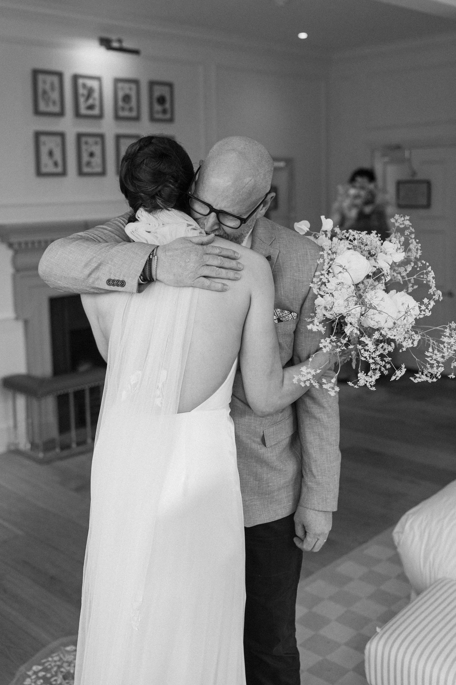 Father and bride sharing a tender embrace during an emotional first look moment.