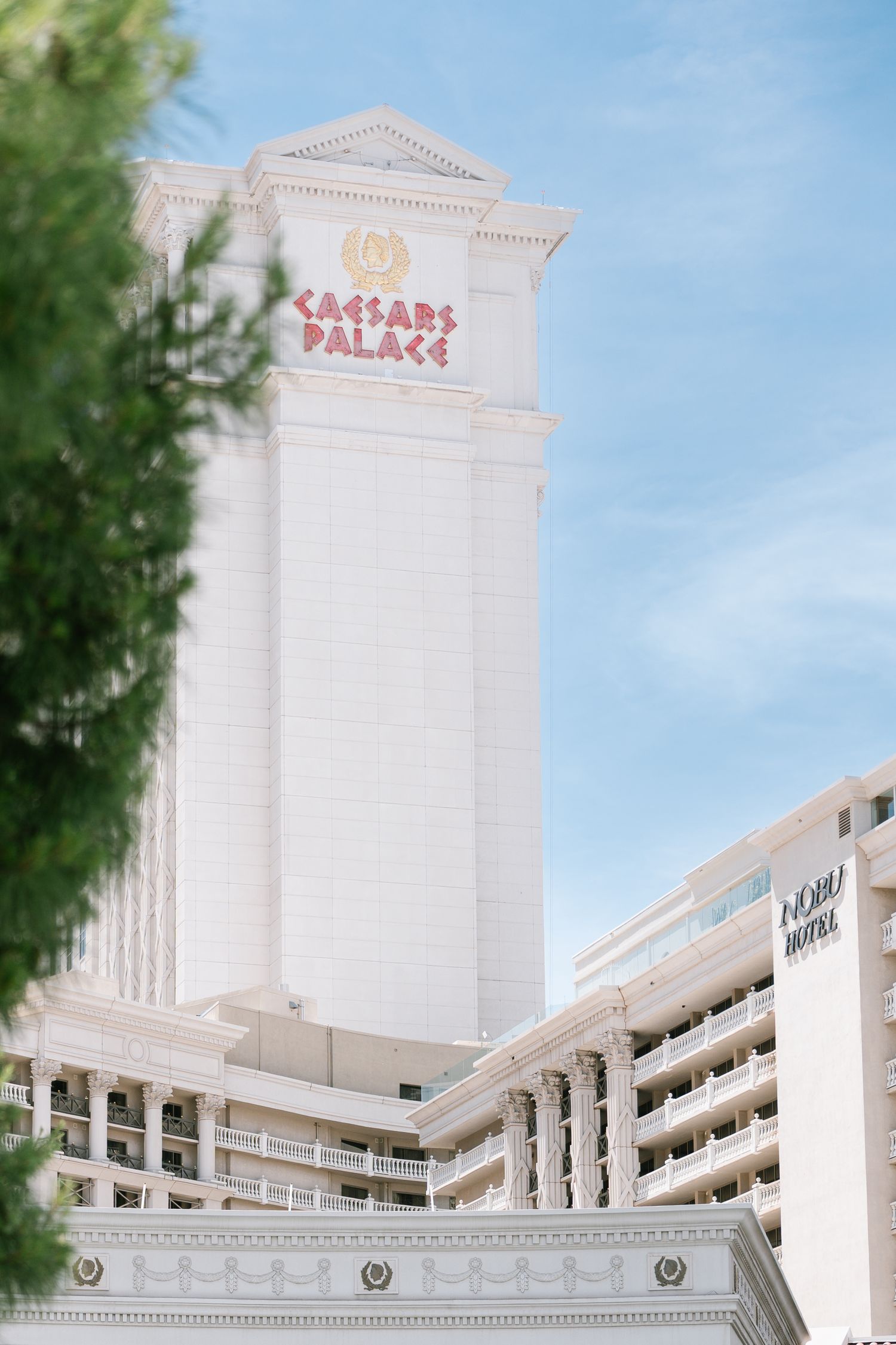 Exterior view of Caesars Palace hotel tower against blue sky in Las Vegas.
