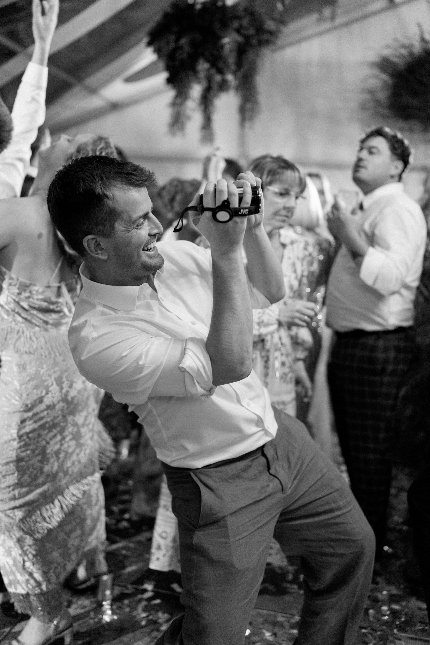 Partygoers dancing and jumping with enthusiasm at an indoor event.