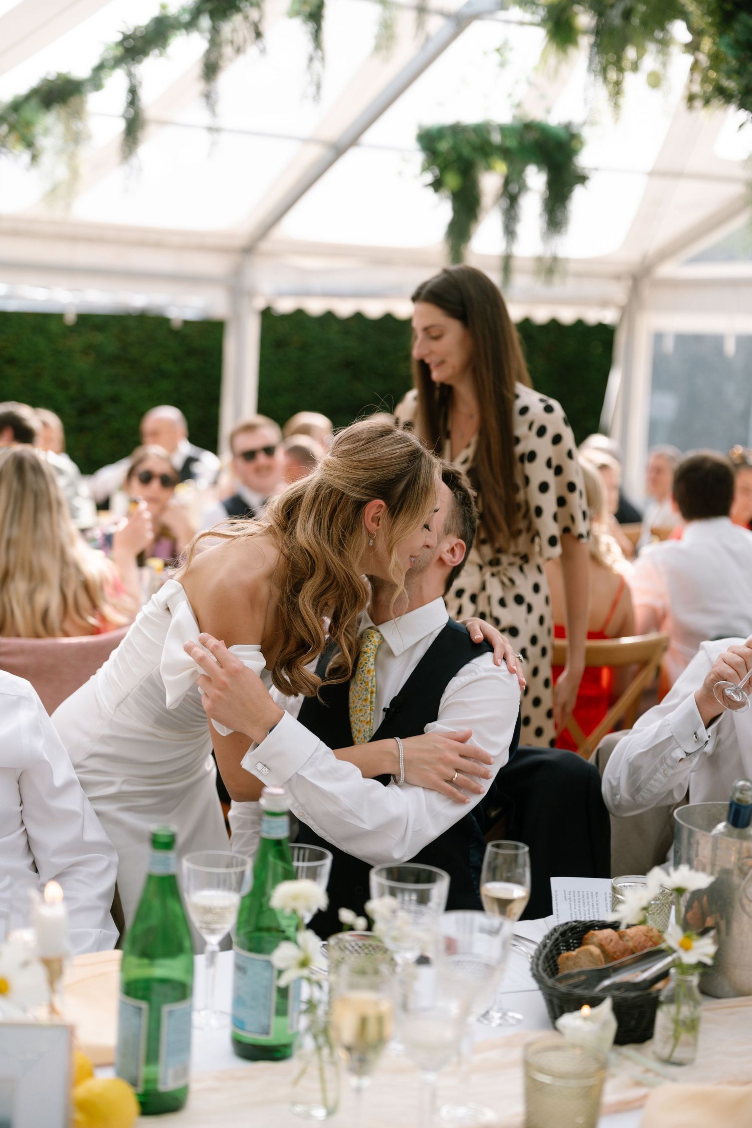 Candid moments of wedding guests laughing and celebrating at a decorated outdoor reception.