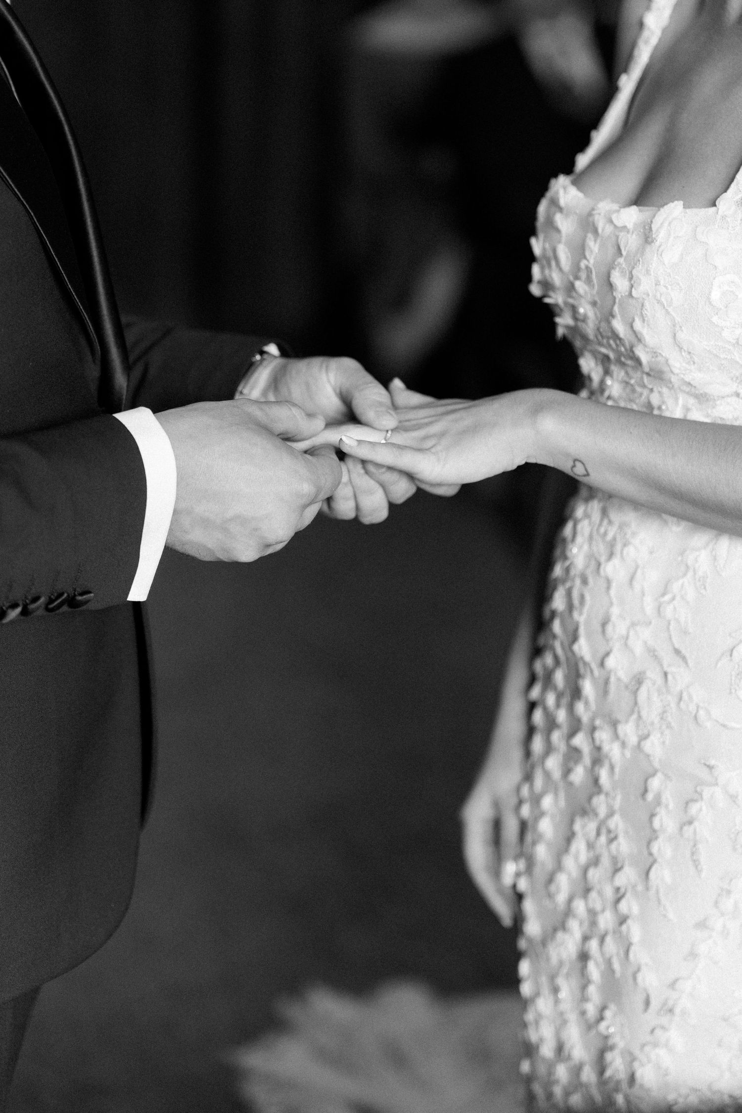 Intimate black and white detail shots of hands during a wedding ceremony.