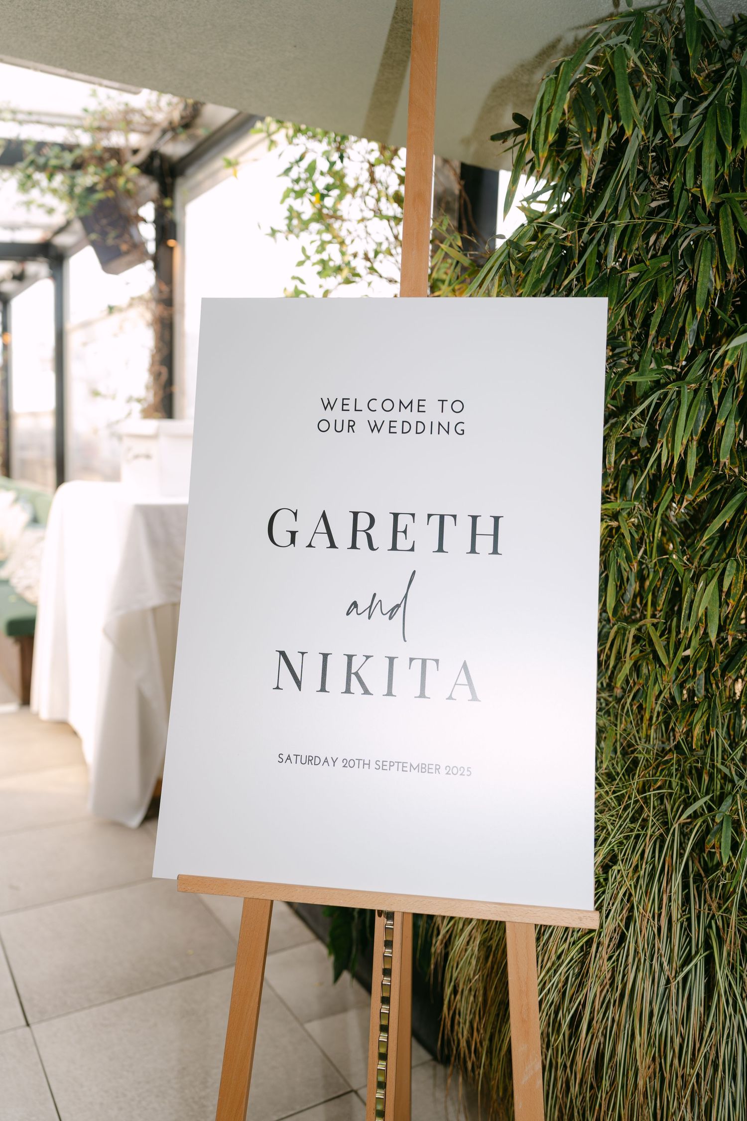 Elegant wedding welcome signs displayed against natural greenery backdrop.