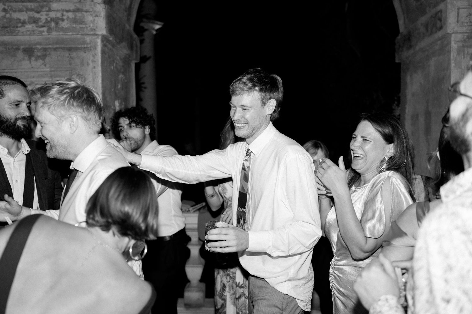 Guests celebrating with raised arms on a crowded dance floor.